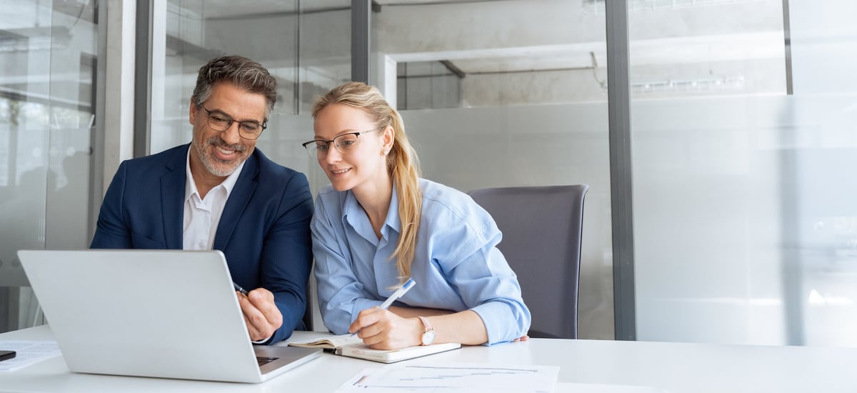 Senior consultant mentoring team member in modern office